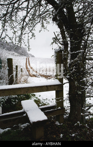 Im Winter Wetter einen Stil zu einem öffentlichen Fußweg überqueren eine verschneite Landschaft in der Chilterns Buckinghamshire UK Stockfoto