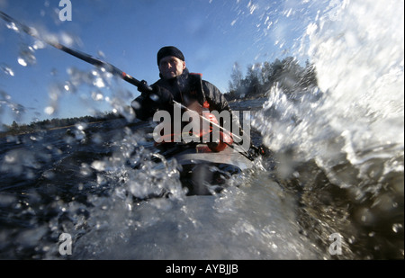 Outdoor Fotograf Øyvind Martinsen ist Paddeln im Kajak bei windigem Wetter auf dem See Vansjø, Østfold fylke, Norwegen. Stockfoto