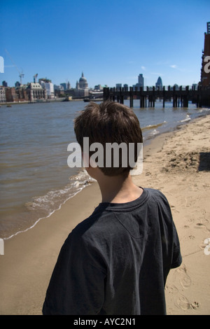 Rückansicht eines jungen Blick über den Fluss Themse in London in der Stadt auf dem gegenüberliegenden Ufer des Flusses Stockfoto