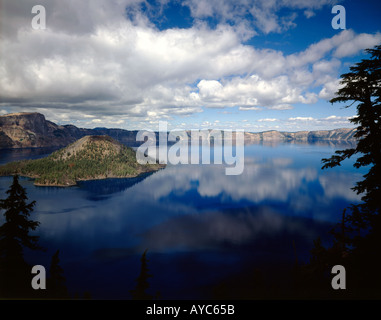 Crater Lake Nationalpark in Oregon mit Wizard Island und dem ruhigen Seewasser reflektiert die Wolke gefüllt Himmel Stockfoto