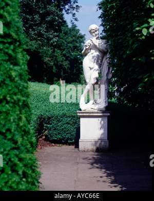Statue des Gottes Pan hinter Hecke im Garten von The Dutch House Kew Gardens in London England Stockfoto