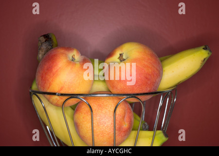 Draht-Korb Obstschale mit Nektarinen und Bananen Stockfoto