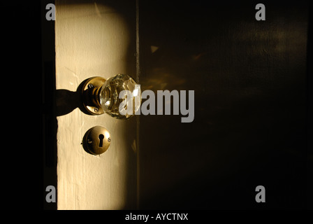 Detail eines alten altmodischen Kristall Türklinke und Schlüsselloch von der Morgensonne beleuchtet Stockfoto