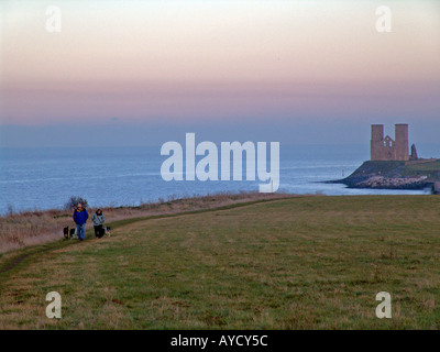 Wandern entlang der Klippen am Sonnenuntergang normannischen Kirche im Hintergrund, Reculver england Stockfoto