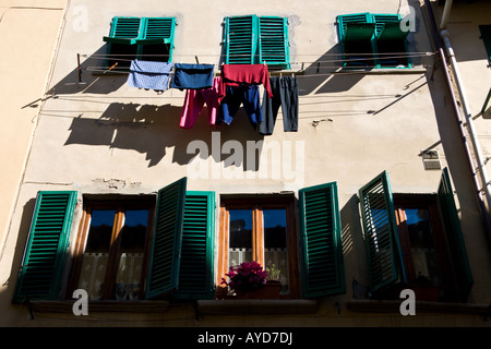 Waschen hängen zum Trocknen von shuttered Fenster in einer Straße in Florenz. Stockfoto