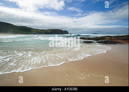 Wellen, die gegen einen Felsvorsprung in Sandwood Bay, Sutherland, Schottland, Großbritannien Stockfoto