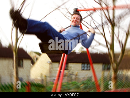 Mann mittleren Alters auf Schaukel Stockfoto