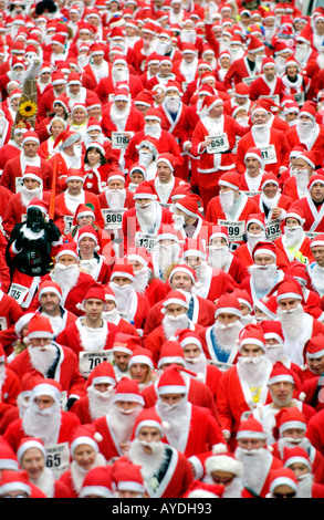 Mehr als 4000 Menschen aller Altersgruppen für die jährlichen Charity-Santa Fun Run in Newtown Powys Wales UK als Weihnachtsmann verkleidet Stockfoto