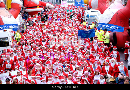 Mehr als 4000 Menschen aller Altersgruppen für die jährlichen Charity-Santa Fun Run in Newtown Powys Wales UK als Weihnachtsmann verkleidet Stockfoto