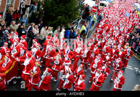 Mehr als 4000 Menschen aller Altersgruppen für die jährlichen Charity-Santa Fun Run in Newtown Powys Wales UK als Weihnachtsmann verkleidet Stockfoto