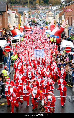 Mehr als 4000 Menschen aller Altersgruppen für die jährlichen Charity-Santa Fun Run in Newtown Powys Wales UK als Weihnachtsmann verkleidet Stockfoto