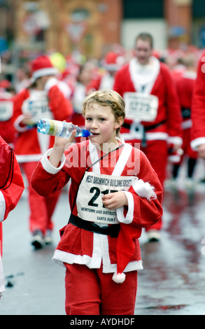 Mehr als 4000 Menschen aller Altersgruppen für die jährlichen Charity-Santa Fun Run in Newtown Powys Wales UK als Weihnachtsmann verkleidet Stockfoto