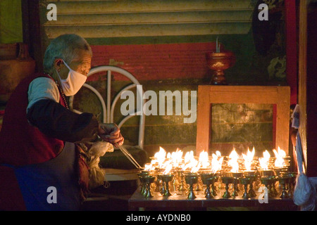 Tibetischer Mönch tendenziell Butter Kerzen auf einem Schrein in ein kleines Kloster befindet sich in Lhasa-Tibet yak Stockfoto