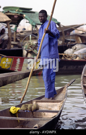 Ein Mann treibt seine traditionellen Holzboot oder Einbaum auf dem Niger in Mopti Mali Stockfoto
