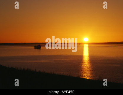Dh Sunset SCAPA FLOW ORKNEY Öltanker und Sonnenuntergang über Flotta und Hoy orange sun Nordsee Stockfoto