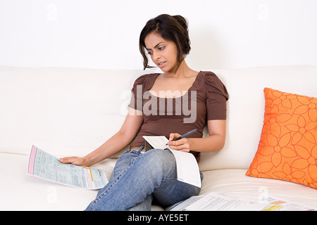 Eine Frau, die einen Scheck schreibt Stockfoto