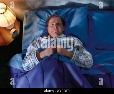 Mann wach im Bett nicht schlafen zu legen. Stockfoto