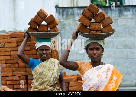 Frauen, die Ziegel auf einer Baustelle in Tiruchirappalli oder Trichy Südindien Stockfoto