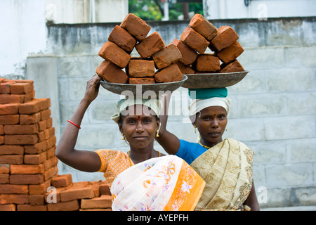 Frauen, die Ziegel auf einer Baustelle in Tiruchirappalli oder Trichy Südindien Stockfoto