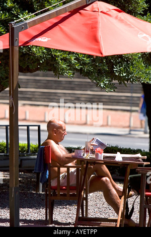 Mann sitzt in einem Straßencafé Lesen einer Zeitschrift in Buenos Aires Argentinien Stockfoto