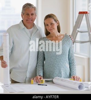 Paar neben Blaupausen Stockfoto