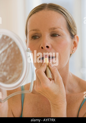 Frau Auftragen von Lippenstift Stockfoto