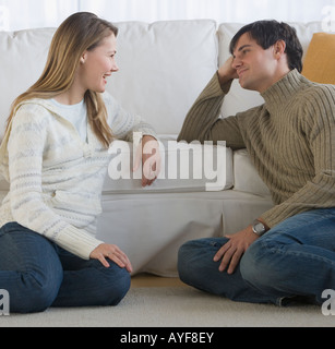 Paar sitzt am Boden sprechen Stockfoto