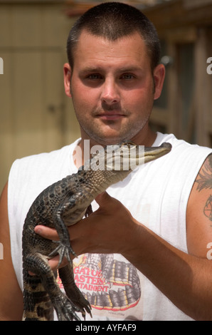 Ein Mann, der während einer Live-Alligatorshow in Miami, Florida, USA, einen Baby-Alligator hält. Stockfoto