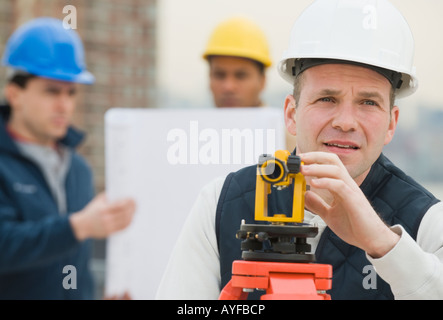 Männliche Landvermesser Durchsicht Messgerät Stockfoto