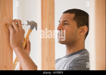 Afrikanischer Mann Hämmern Nagel Stockfoto