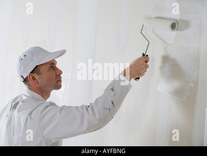 Männliche Maler malen mit Farbroller Stockfoto