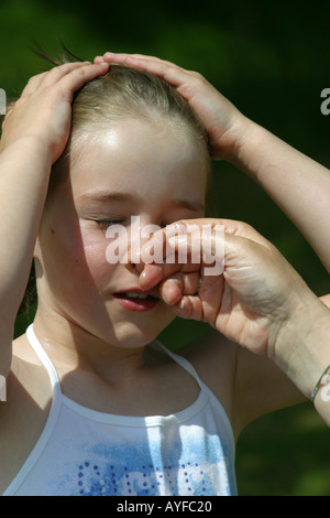 Mutter, die Anwendung von Sonnenschutzmitteln, junge Mädchen Gesicht Stockfoto