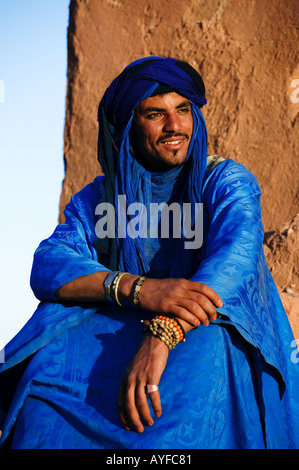 Tuareg-Mann gekleidet in traditioneller Kleidung mit Kasbah Ait Benhaddou im Hintergrund Ouarzazate Marokko Stockfoto