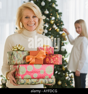 Ältere Frau mit Stapel von Weihnachtsgeschenke Stockfoto