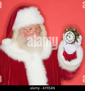 Santa Claus Holding Wecker Stockfoto