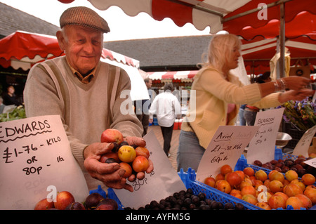 EIN STANDBESITZER ZEIGT SEINE FRISCHE PRODUKTE AUF DEM BAUERNMARKT IN STROUD GLOUCESTERSHIRE UK Stockfoto