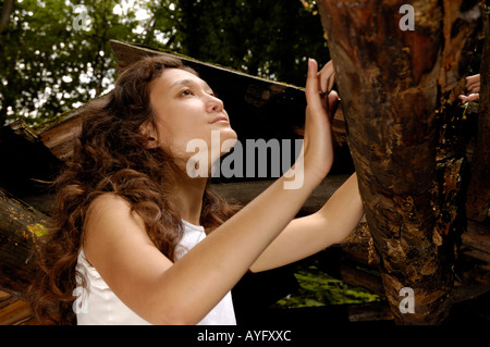 Junge Frau in einem zerstörten Holzhaus Stockfoto