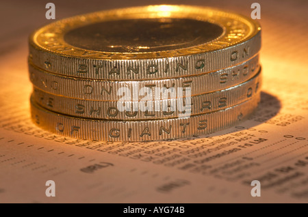 England, UK. Stapel von zwei Pfund Münzen auf einer Kopie der Financial Times stapeln buchstabieren 'Stehende auf der Schulter des Riesen" Stockfoto