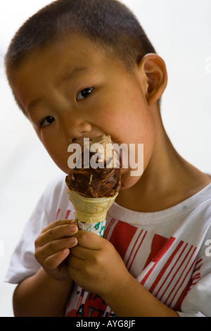 Junge chinesische Kind isst Schokolade getauchten Schokolade Iced Creme Kegel, Peking, China Stockfoto