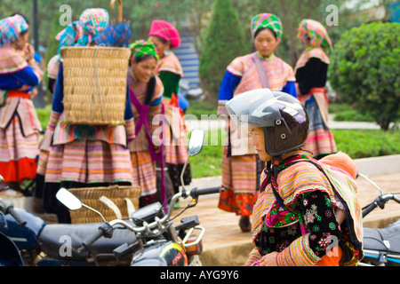 Blumenmarkt Hmong Frau trägt eine schützende Motorrad Helm Bac Ha in der Nähe von Sapa Vietnam Stockfoto