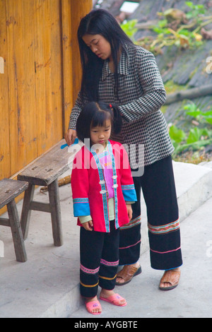 Zhuang Minderheit Mutter Kämmen junge Tochter tragen traditionelle Kleidung Ping An Longsheng China Stockfoto