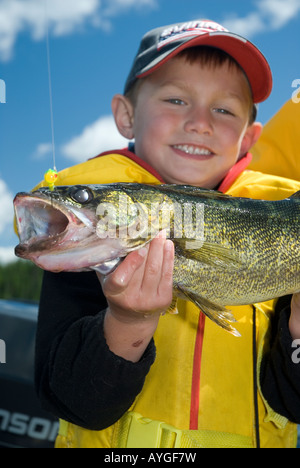 JUNGE MIT ZANDER FISCH AM NÖRDLICHEN ONTARIO-SEE Stockfoto