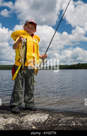 Junge fängt Zander von der Küste entfernt Stockfoto