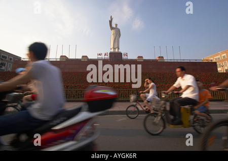 Radfahrer fahren vorbei an Mao Zedong Statue In Tianfu Platz, Chengdu, China Stockfoto