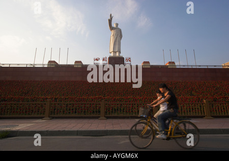 Radfahrer fahren vorbei an Mao Zedong Statue In Tianfu Platz, Chengdu, China Stockfoto