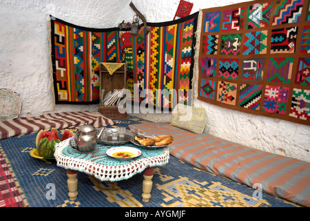 Tee, Brot und Obst für Besucher in unterirdischen Berber Höhlenwohnungen mit bunten Wand Hangings Matmata Tunesien nach Hause dargelegt Stockfoto