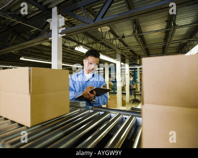 Asiatischen männlichen Fabrikarbeiter Produkt prüfen Stockfoto