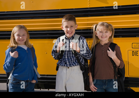 Kinder mit Rucksäcke vor Schulbus Stockfoto