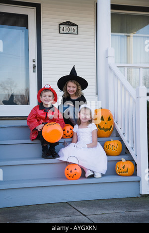 Kinder in Halloween-Kostümen auf Veranda Stockfoto