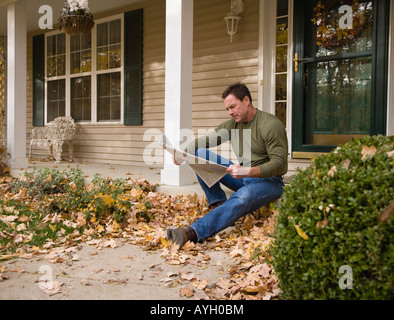 Menschen lesen Zeitung auf Veranda Stockfoto